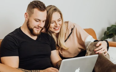 Ein Mann und eine Frau schauen auf ein Laptop